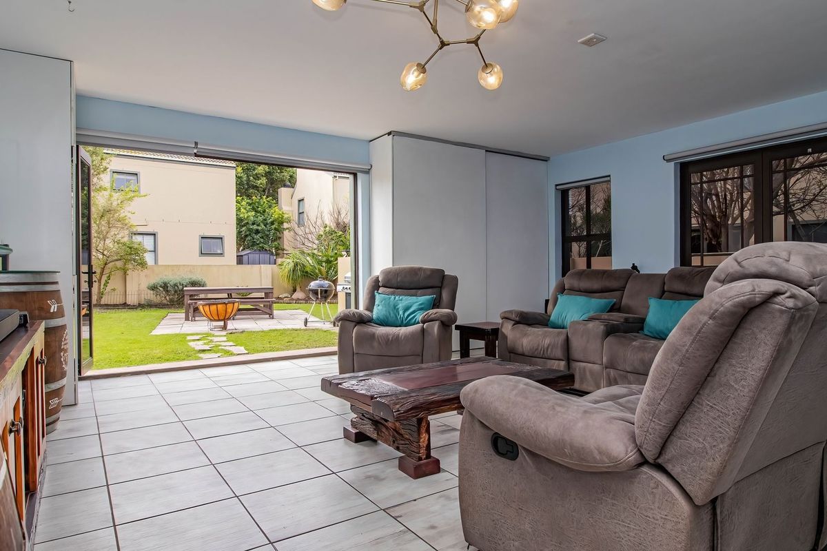 Spacious living room featuring tiled flooring and large sliding glass doors that provide seamless access to the rear garden area.