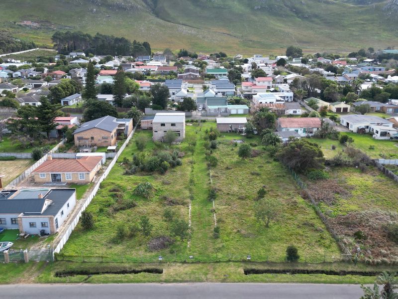 An aerial view of a vacant residential plot situated in a developed neighborhood, offering a clear perspective of the land and surrounding properties.