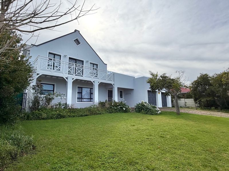 Front view of a two-story house featuring a balcony, double garage, and a well-maintained front lawn.