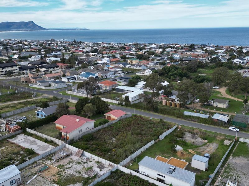 Aerial view of a residential vacant land plot situated in a coastal neighborhood with established street access and surrounding residential properties.