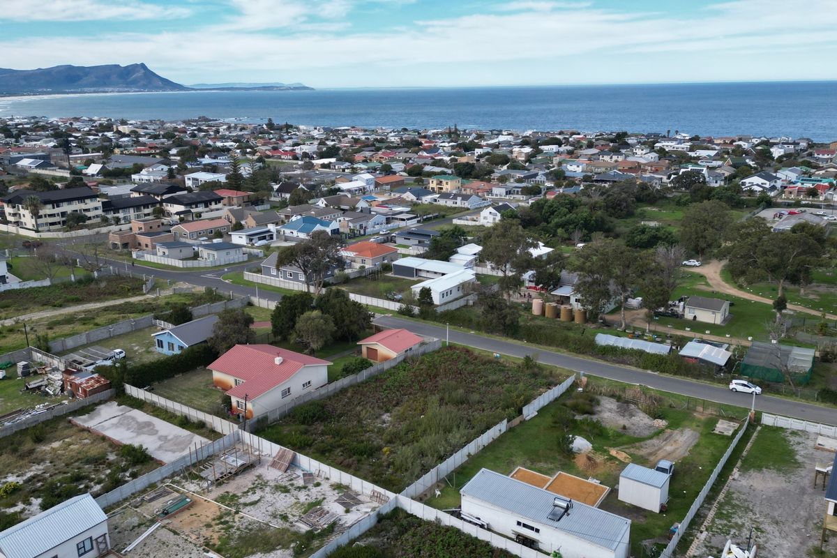 Aerial view of a residential vacant land plot situated in a coastal neighborhood with established street access and surrounding residential properties.