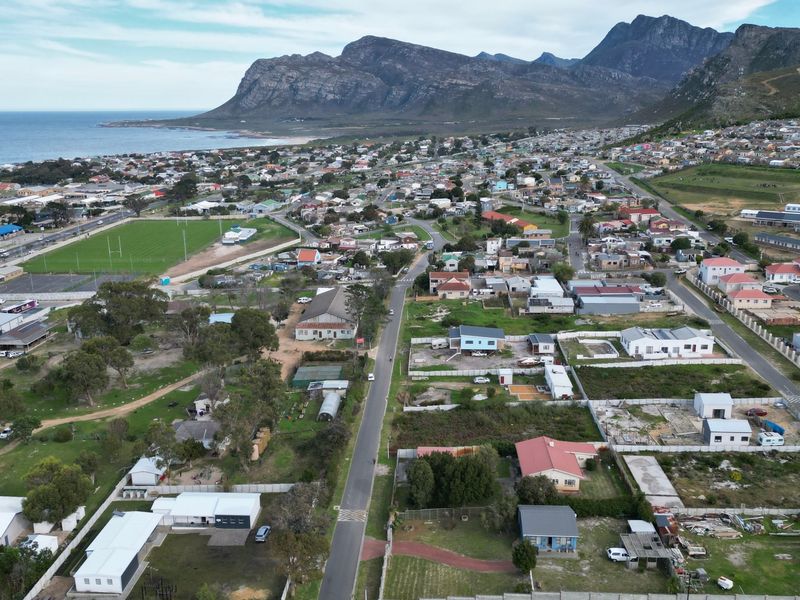 Aerial view of a coastal residential neighborhood featuring mountain vistas and proximity to the ocean.