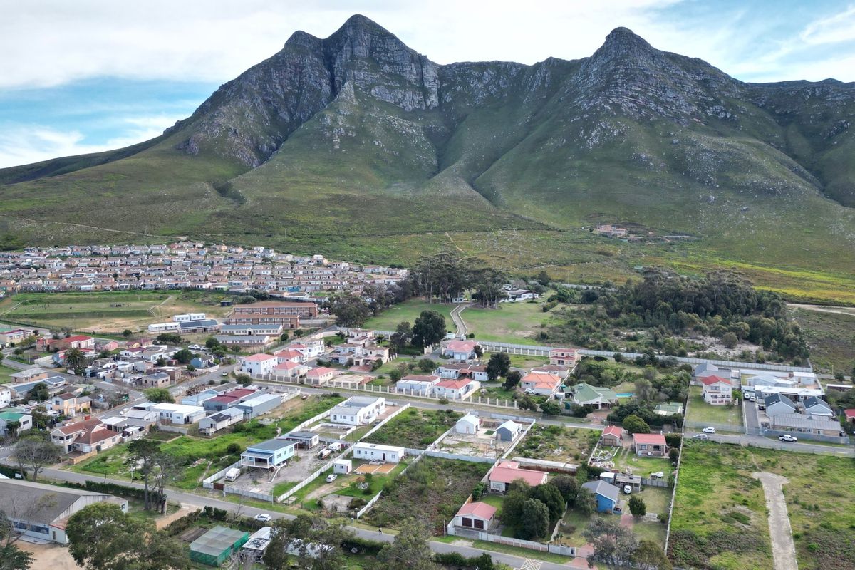 Aerial view of a residential neighborhood situated at the base of a prominent mountain range, showcasing the surrounding landscape and community layout.
