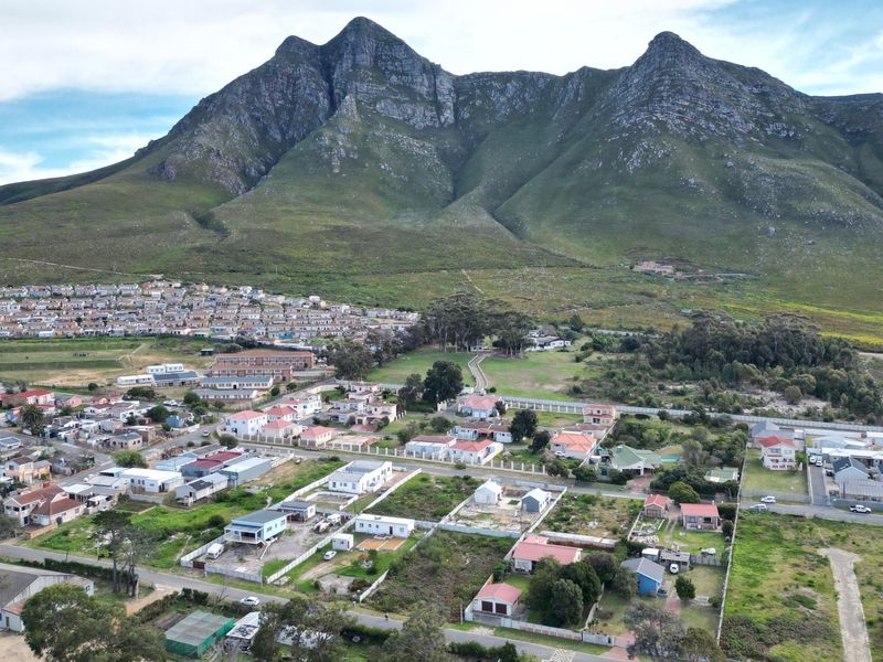 Aerial view of a residential neighborhood situated at the base of a prominent mountain range, showcasing the surrounding landscape and community layout.