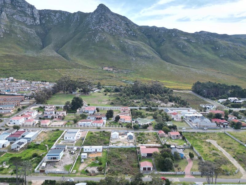 Aerial view of a residential neighborhood featuring vacant land plots set against a scenic mountain backdrop.