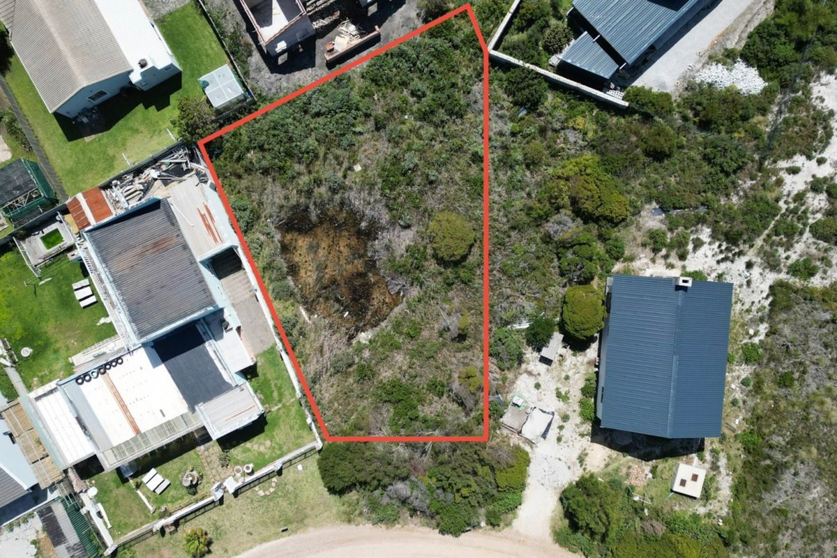 Aerial view of a vacant residential plot with defined boundaries, situated in a developed neighborhood.