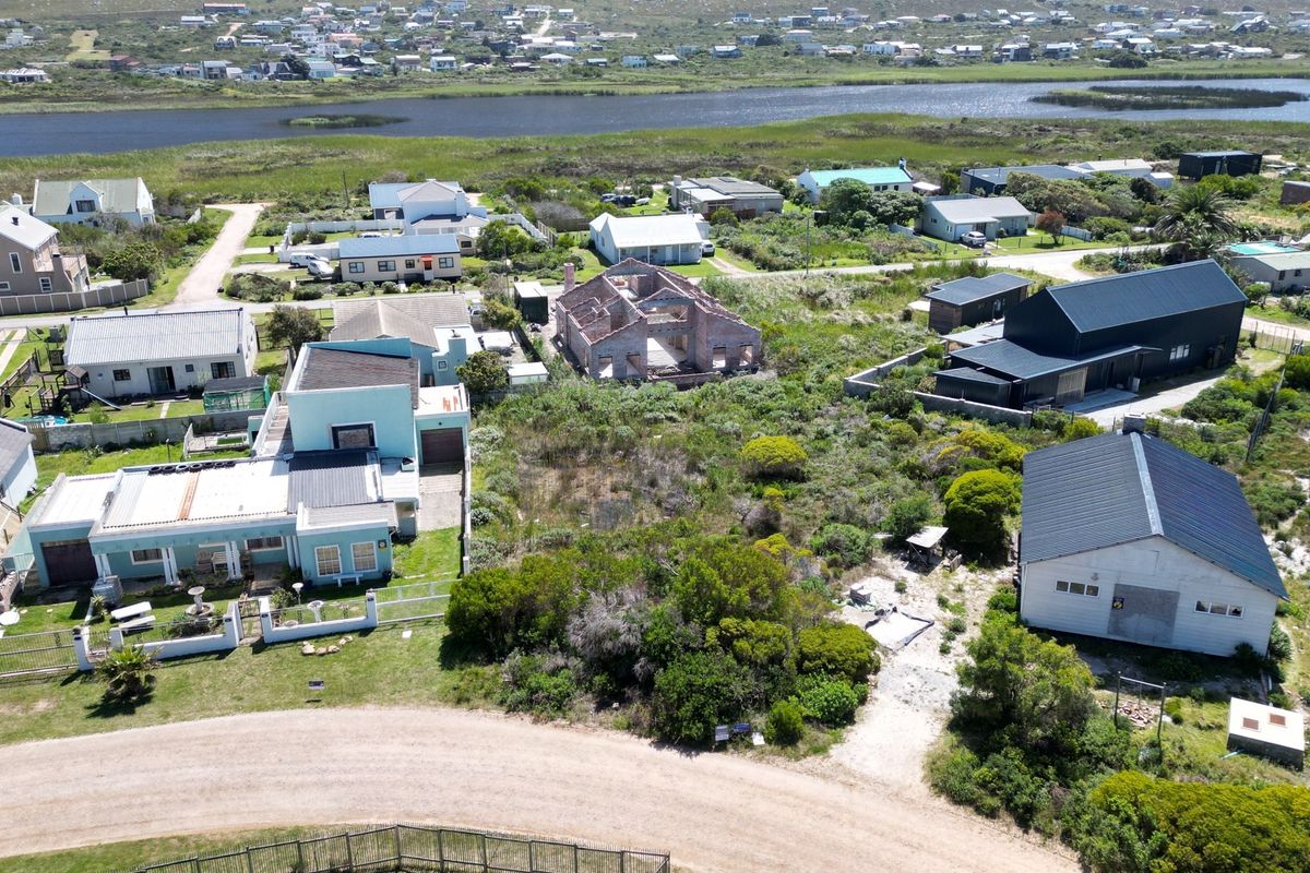 Aerial view of a residential vacant land plot situated within an established coastal neighborhood, offering potential for new development.