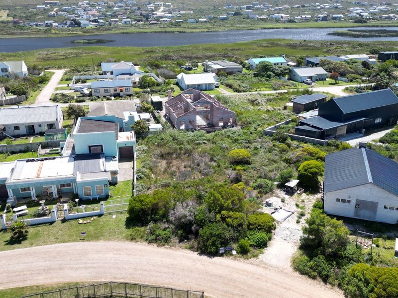 Aerial view of a residential vacant land plot situated within an established coastal neighborhood, offering potential for new development.
