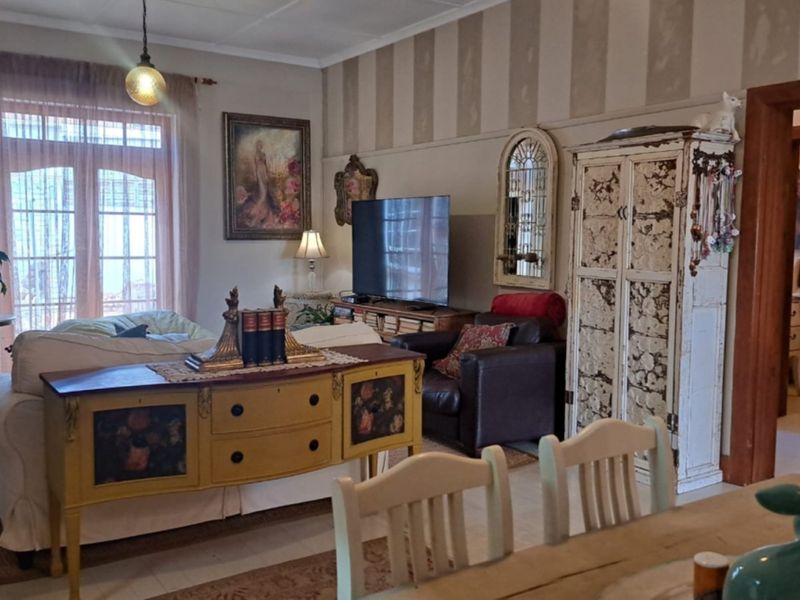 A living room featuring classic architectural details, including timber door frames and french doors leading to an outdoor area.