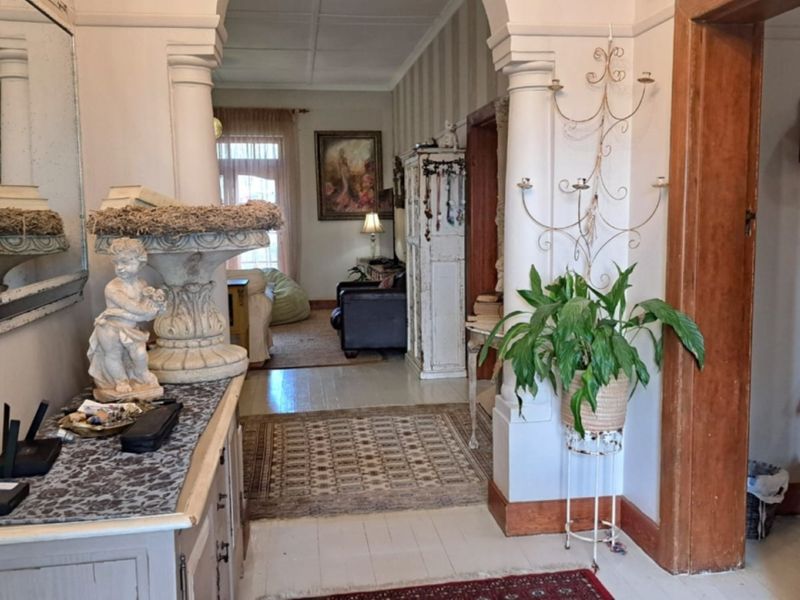 A character-filled hallway featuring classic architectural archways, decorative columns, and original timber door frames leading into the main living area.