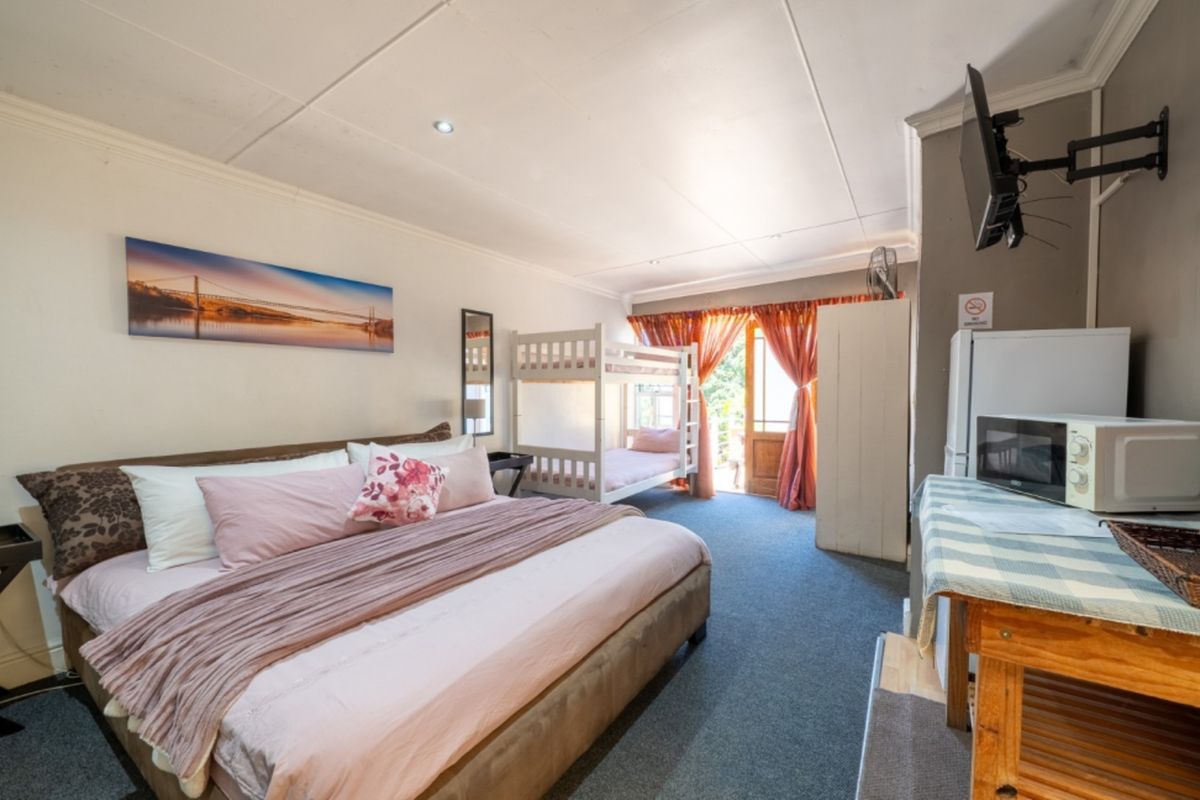 Spacious bedroom featuring carpeted flooring, recessed lighting, and direct access to an outdoor area through a timber-framed glass door.