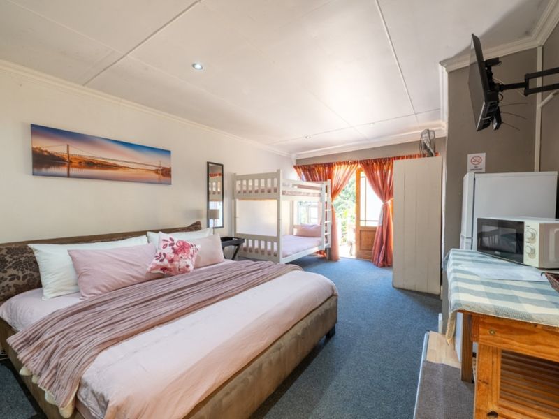 Spacious bedroom featuring carpeted flooring, recessed lighting, and direct access to an outdoor area through a timber-framed glass door.