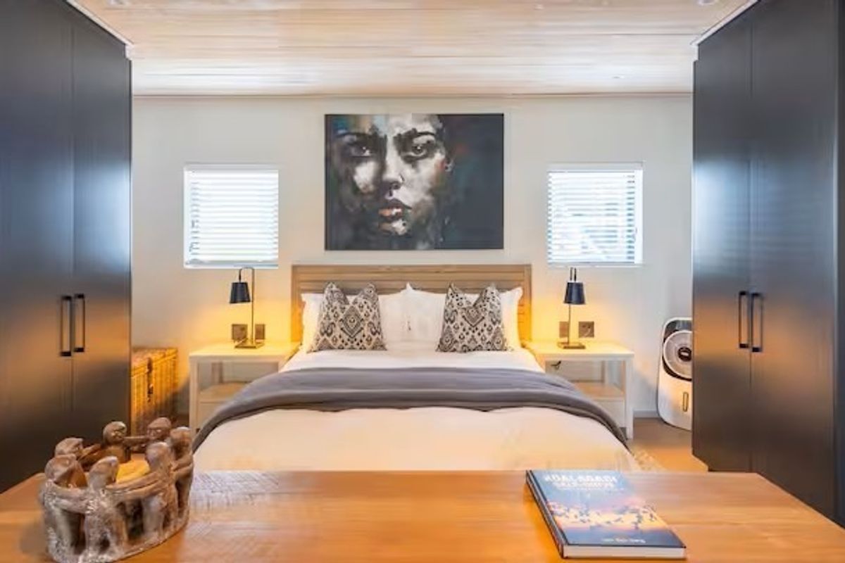A well-appointed bedroom featuring symmetrical built-in wardrobes, a timber-clad ceiling, and recessed lighting, creating a modern and cohesive living space.
