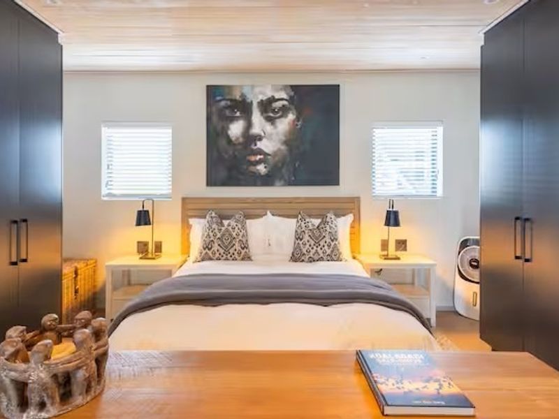 A well-appointed bedroom featuring symmetrical built-in wardrobes, a timber-clad ceiling, and recessed lighting, creating a modern and cohesive living space.