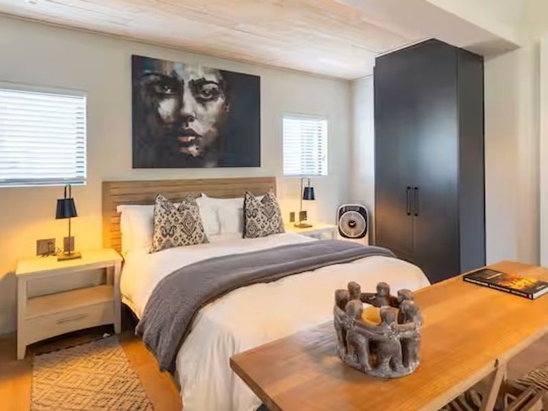 A well-appointed bedroom featuring built-in cupboards, a warm timber ceiling, and modern laminate flooring, creating a comfortable and inviting living space.