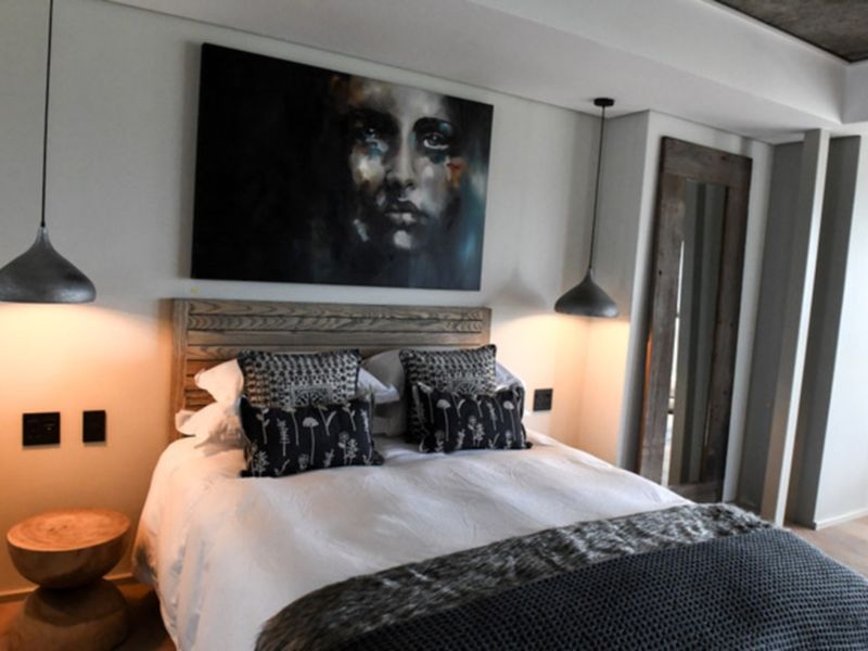 A modern, well-appointed bedroom featuring recessed ceiling lighting, stylish pendant fixtures, and high-quality finishes throughout.