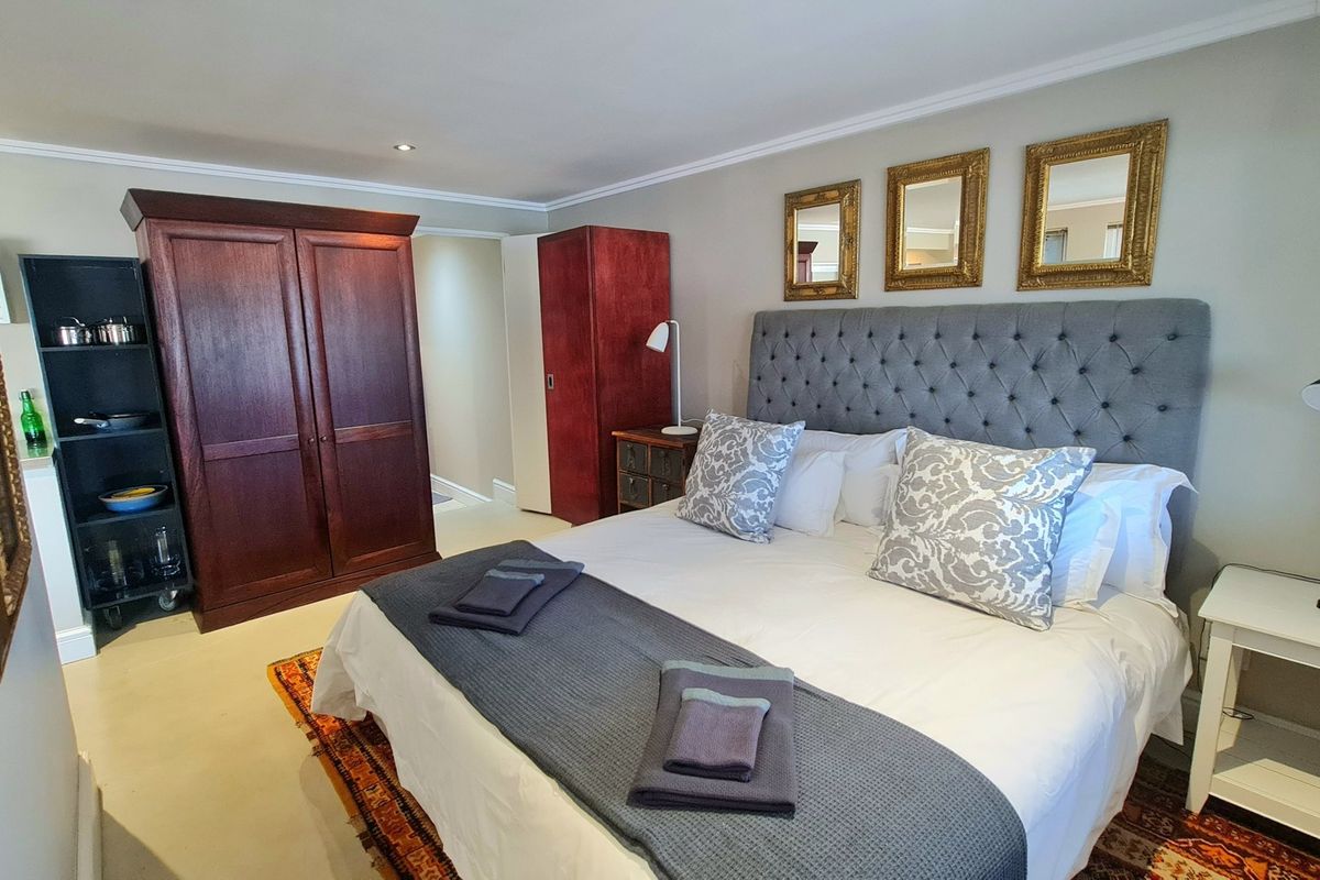 A well-maintained bedroom featuring neutral wall tones, recessed ceiling lighting, and classic crown molding, providing a comfortable and functional living space.