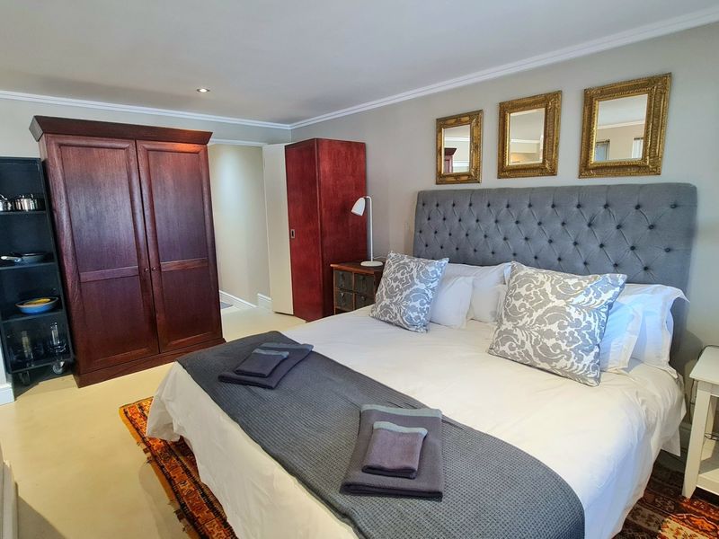A well-maintained bedroom featuring neutral wall tones, recessed ceiling lighting, and classic crown molding, providing a comfortable and functional living space.