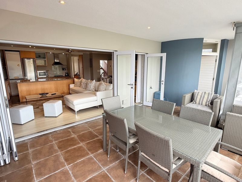 Spacious open-plan living area featuring a seamless transition between the indoor kitchen and the covered outdoor patio with bi-fold doors.