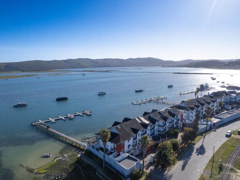 Aerial view of the apartment complex featuring direct waterfront access, private jetties, and proximity to local transport infrastructure.