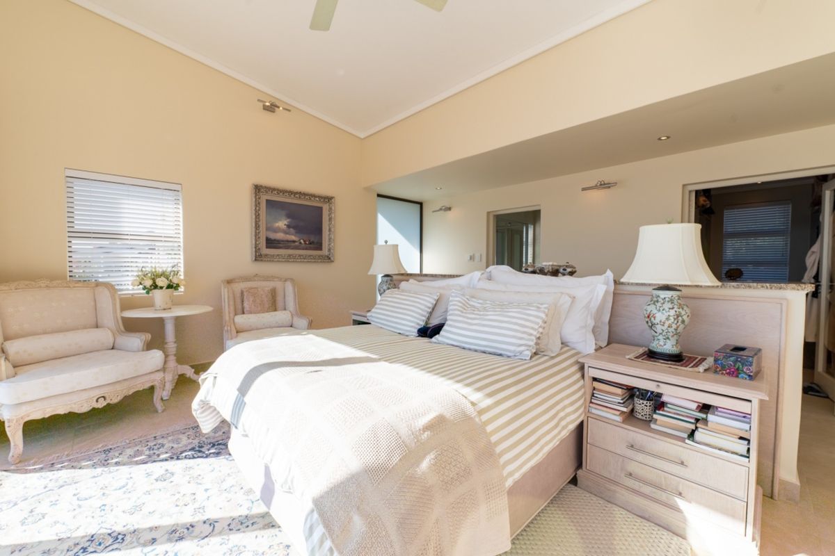 Spacious bedroom featuring a vaulted ceiling, recessed lighting, and a functional built-in headboard partition with a granite ledge.