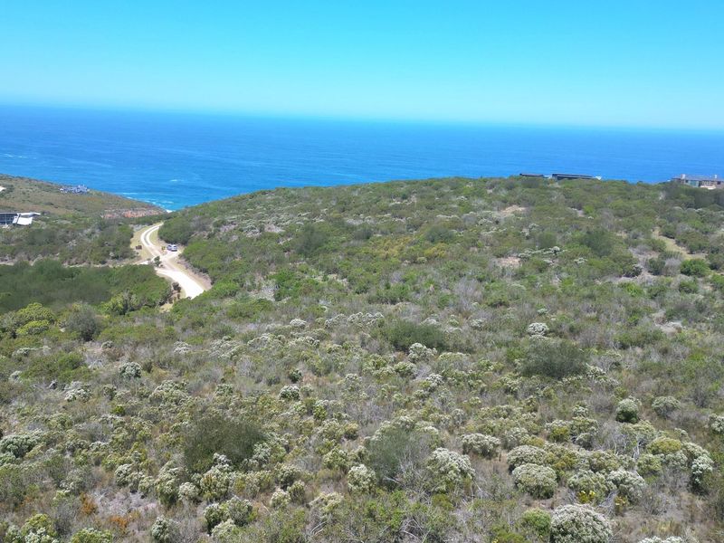 Aerial view of a vacant residential plot featuring natural coastal vegetation and proximity to the ocean.