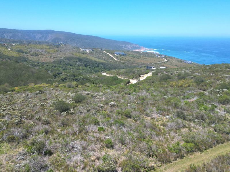 An elevated aerial view of the vacant residential land showcasing the surrounding natural coastal landscape and ocean views.