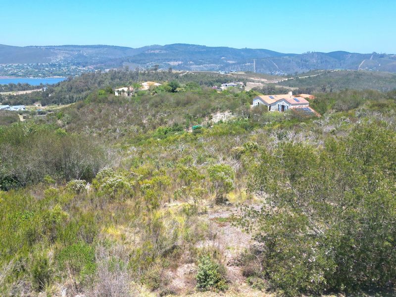 An elevated view of the surrounding natural landscape, featuring rolling hills, native vegetation, and distant coastal scenery.