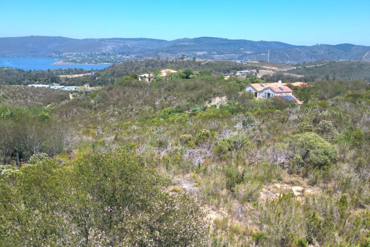 An elevated view of the surrounding natural landscape, rolling hills, and distant water, showcasing the scenic outlook from the residential land.