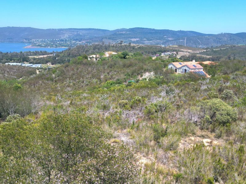 An elevated view of the surrounding natural landscape, rolling hills, and distant water, showcasing the scenic outlook from the residential land.