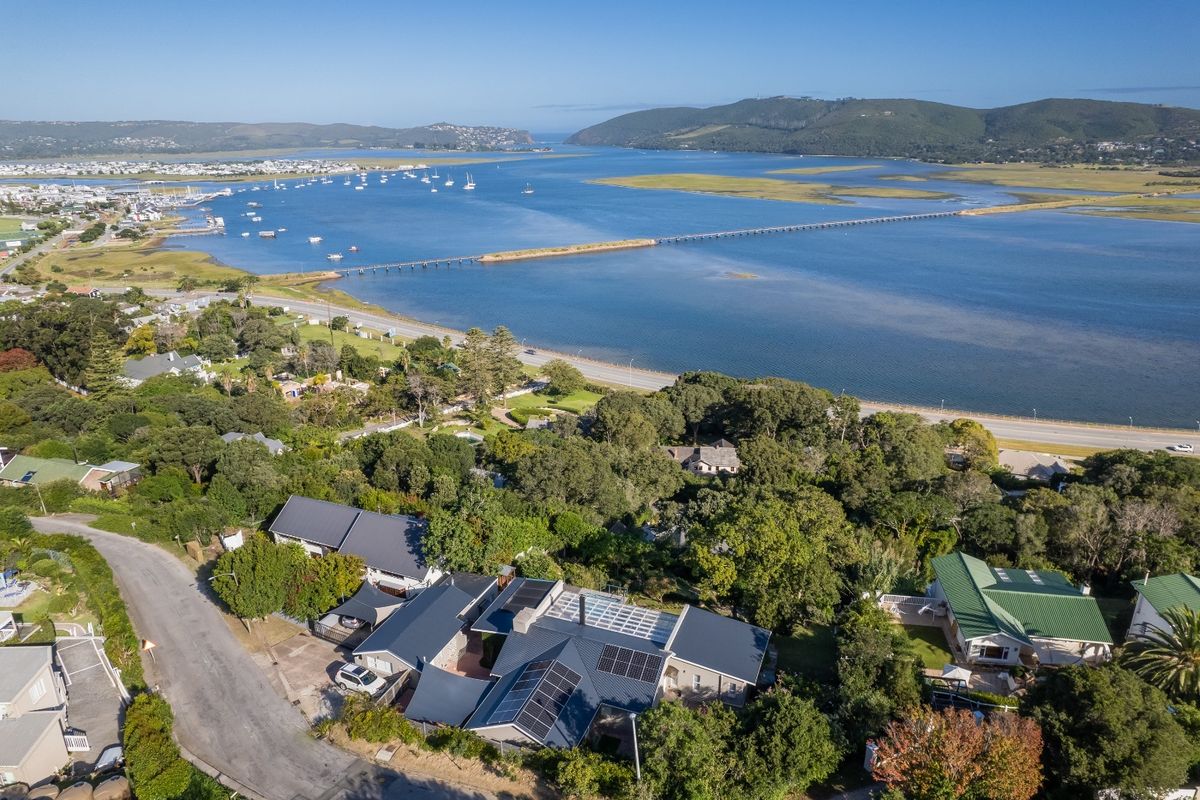 Aerial view of the property featuring a metal roof with integrated solar panels, set in a coastal location overlooking the estuary.