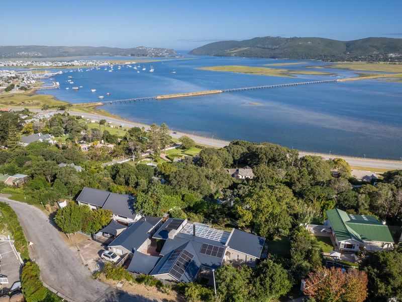 Aerial view of the property featuring a metal roof with integrated solar panels, set in a coastal location overlooking the estuary.