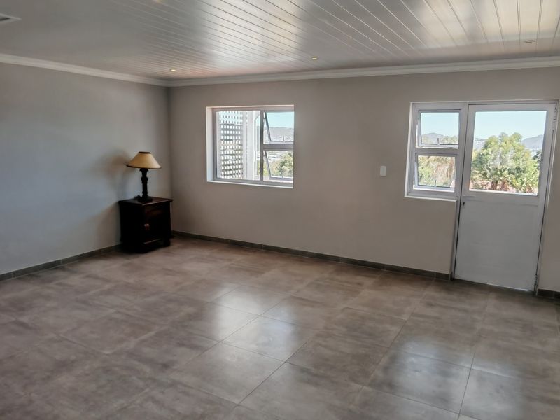 Spacious bedroom featuring neutral tiled flooring, a tongue and groove ceiling with recessed lighting, and direct access to an outdoor area.