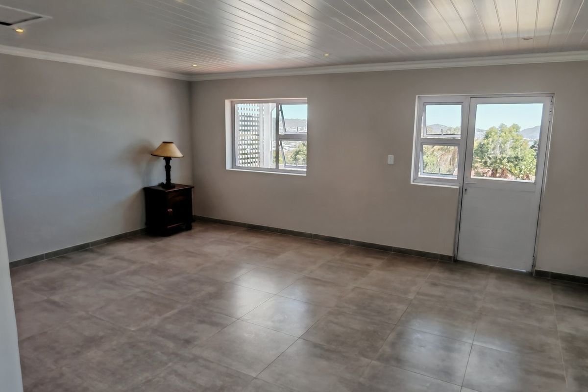 Spacious bedroom featuring neutral tiled flooring, a tongue and groove ceiling with recessed lighting, and direct access to an outdoor area.