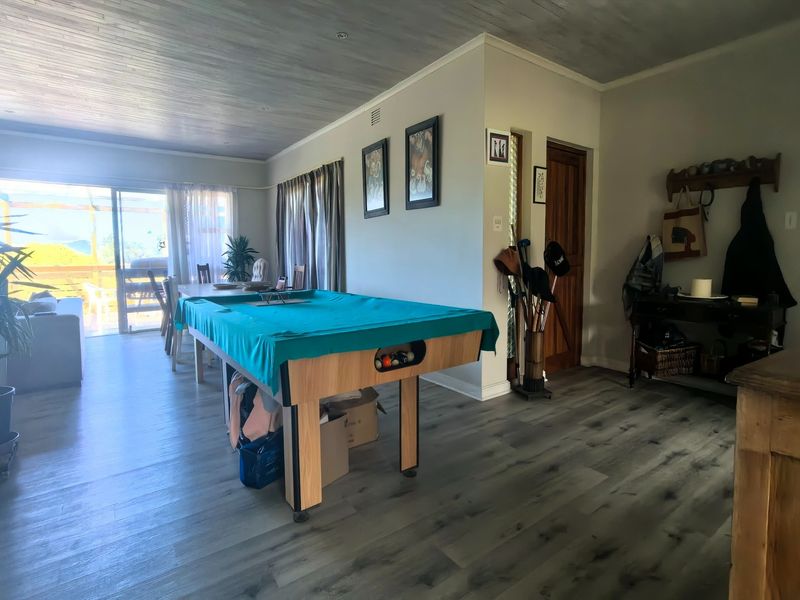 Spacious open-plan living area featuring modern laminate flooring, a fireplace, and large sliding doors providing access to the outdoor patio.