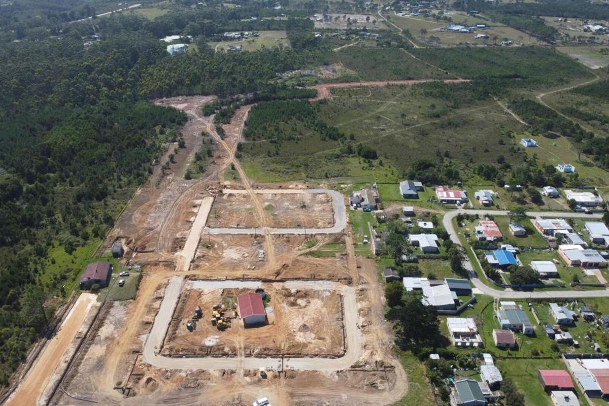Aerial view of a residential development site showing cleared land, established road networks, and surrounding rural landscape.