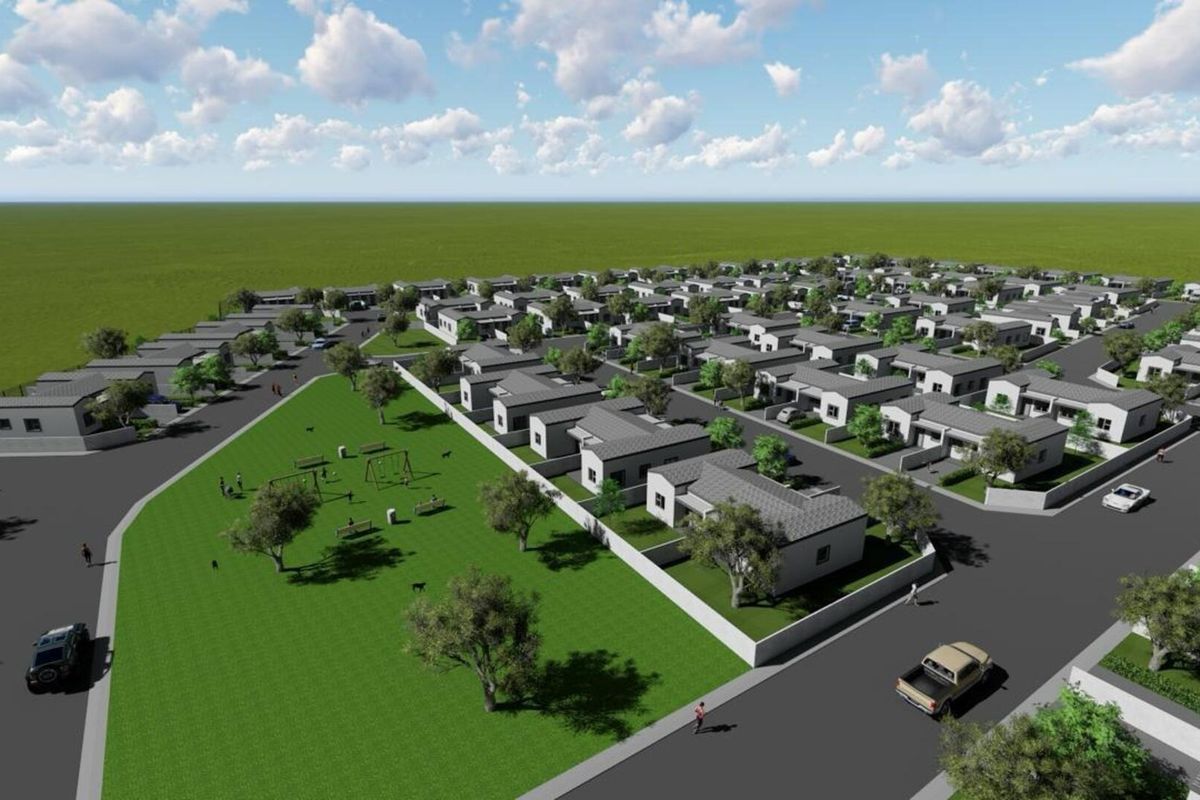 An aerial perspective of a residential development featuring multiple housing units, paved street infrastructure, and a central landscaped park area.