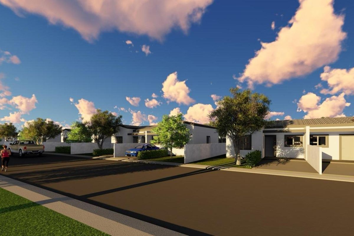 A street-level view of a residential development featuring modern single-story homes with boundary walls and paved access roads.