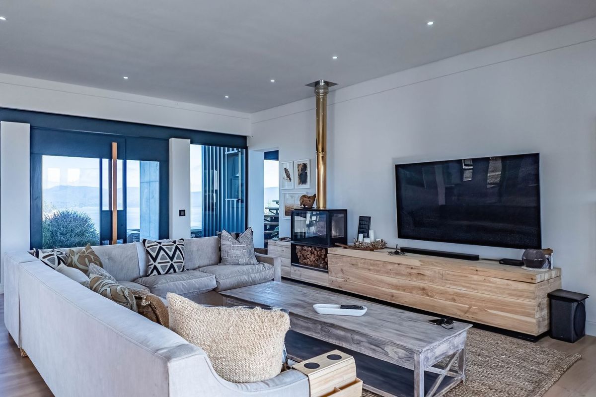 A modern, well-lit living room featuring hardwood floors, a sleek freestanding fireplace, and large sliding glass doors that provide natural light and outdoor access.