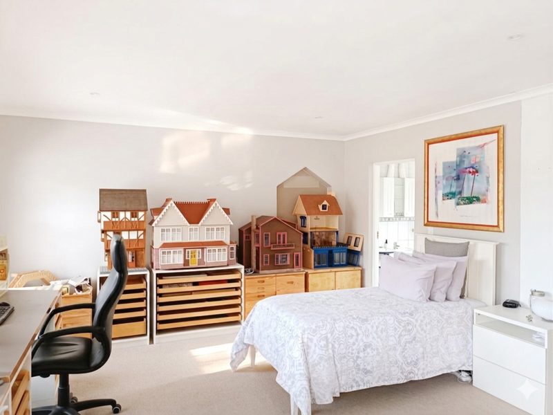 A well-maintained bedroom featuring neutral wall tones, recessed ceiling lighting, and a built-in wall niche, offering a clean and functional living space.