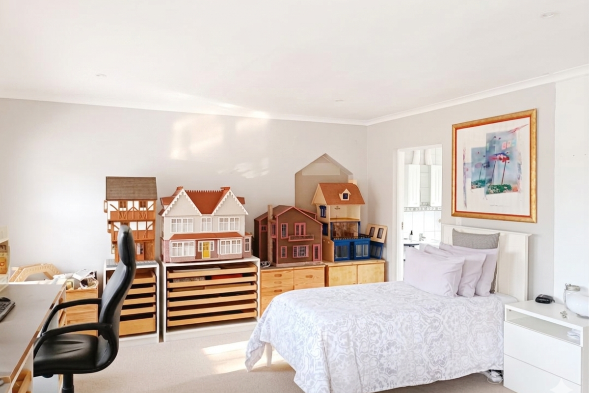 A well-maintained bedroom featuring neutral wall tones, recessed ceiling lighting, and a built-in wall niche, offering a clean and functional living space.