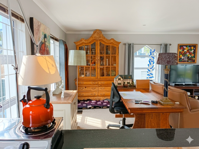 An open-plan living and dining area featuring a granite kitchen countertop, coved ceilings, and natural light through large sliding glass doors.