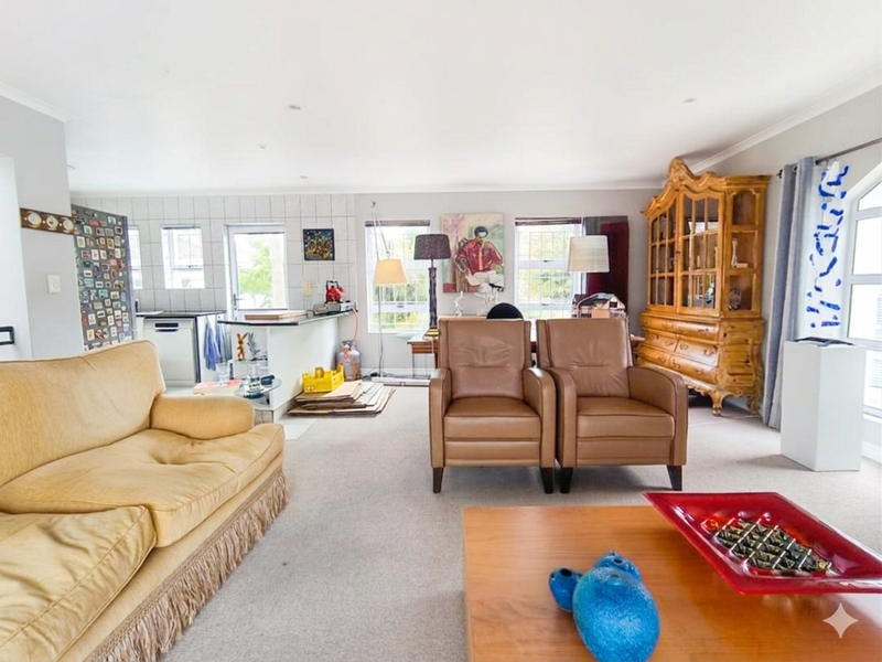 Spacious open-plan living area featuring a combined lounge and kitchen space with neutral finishes and ample natural light.