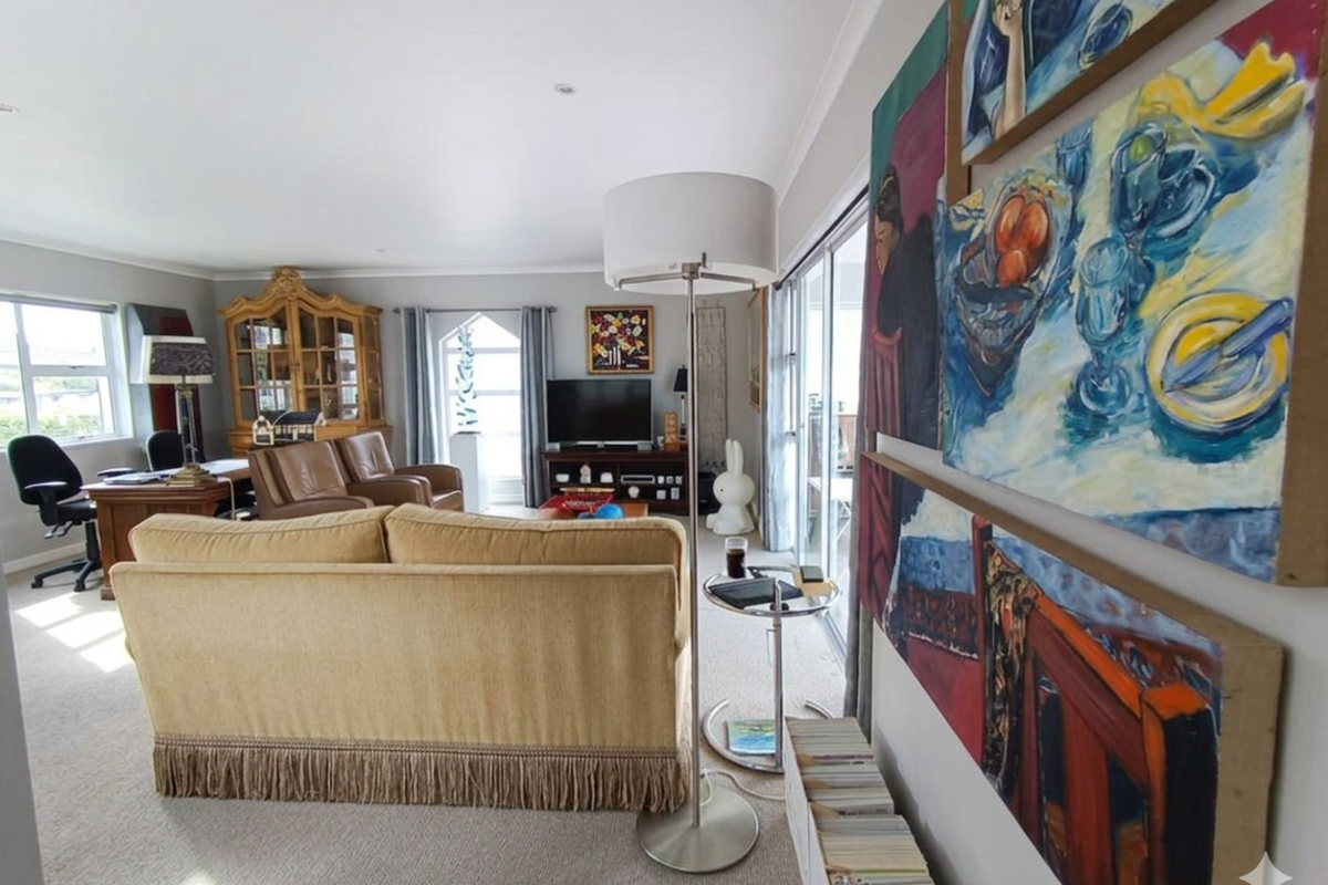 Spacious living room featuring neutral carpeting, recessed lighting, and large sliding glass doors that provide access to an outdoor area.