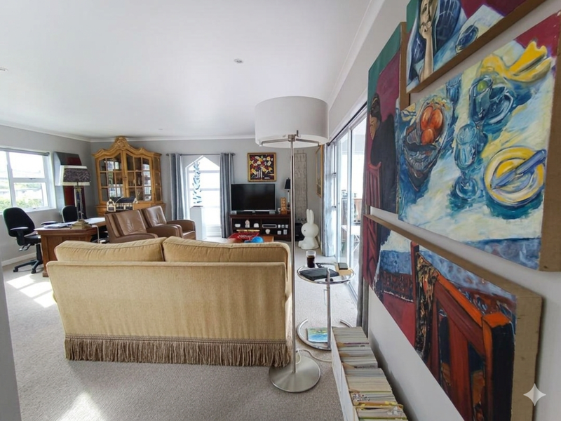 Spacious living room featuring neutral carpeting, recessed lighting, and large sliding glass doors that provide access to an outdoor area.