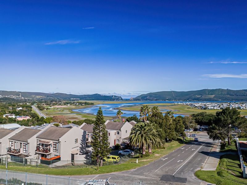 Elevated panoramic view overlooking the estuary, surrounding residential area, and distant hills, showcasing the property's scenic location.