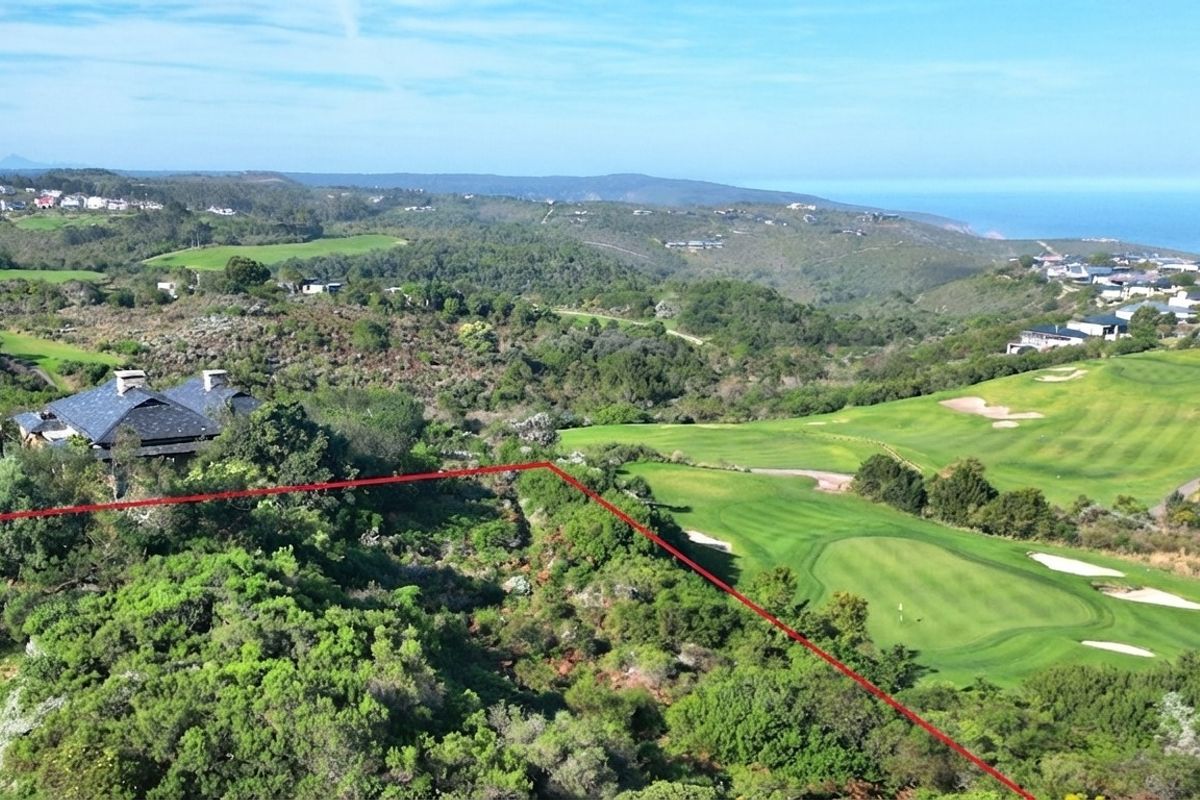 Aerial view of a vacant residential plot situated within a scenic golf estate, featuring expansive coastal and landscape views.