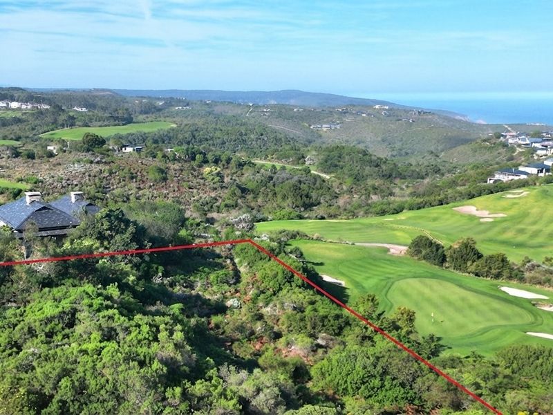 Aerial view of a vacant residential plot situated within a scenic golf estate, featuring expansive coastal and landscape views.