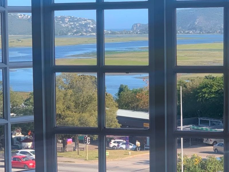 A scenic elevated view of the estuary and surrounding landscape captured through grid-pane windows.