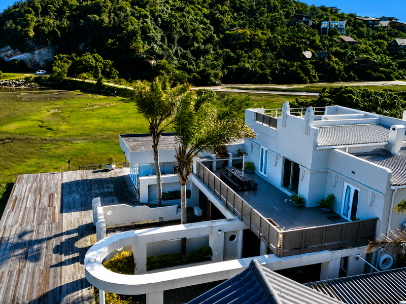 Aerial view of a multi-level residence featuring extensive timber decking, a spacious balcony, and a scenic outlook over the surrounding landscape.